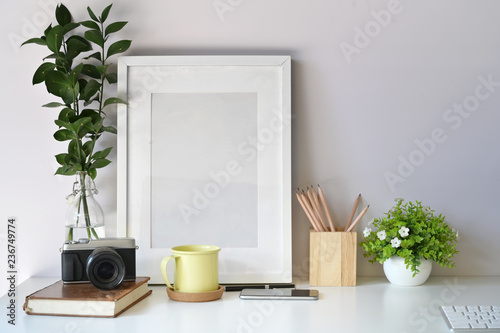 Mockup poster template with vintage camera, supplies on white desk workspace and copy space © bongkarn