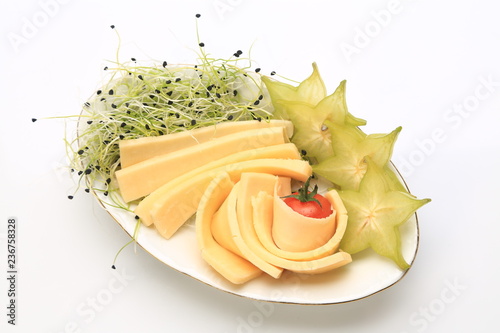 Slices of chhese with slices of starfruit and sprouts on the side photo