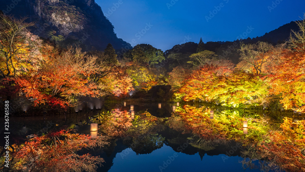 Beautiful Japanese garden named Mifuneyama Rakuen in autumn night view with maple leaves and lake reflection.