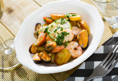 Stewed slices of potato with seafood