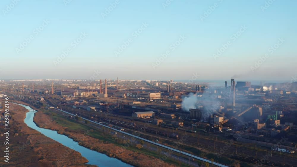Industrial enterprise on the river bank in the city. Evening time. . Aerial view Industrial enterprise on the river bank in the city. Evening time. . Aerial view