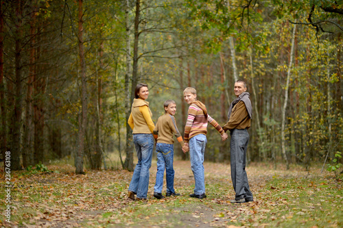 Portrait of family of four walking in autumn forest