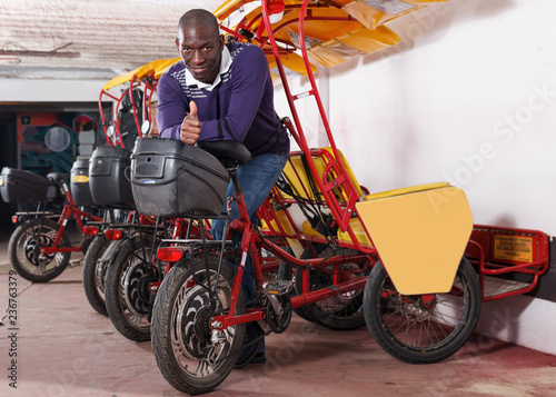 African-American man bikecab driver standing near rickshaw cycle photo