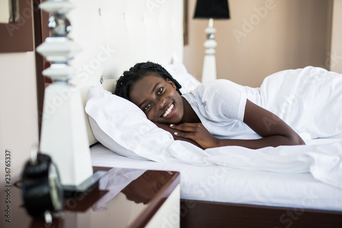 Cute afro american woman lying on her back in her bedroom