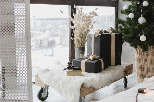 Boxes with gifts lie on a sled under the Christmas tree, an element of home interior