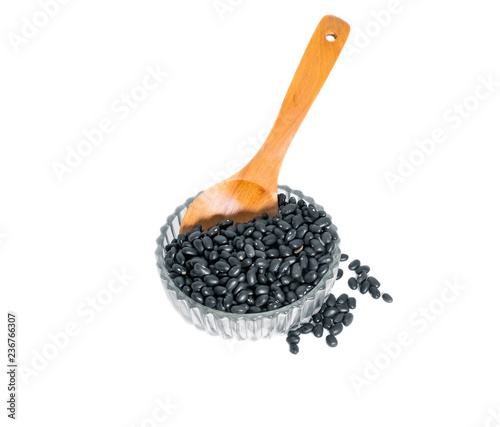 black beans with wooden spoon in clear Glass bowl on white background