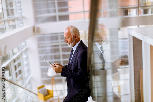 Senior businessman using di...