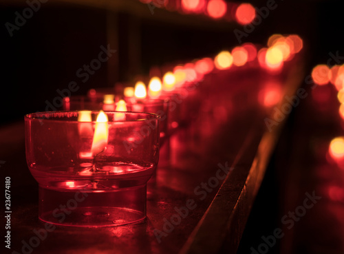 Row of candles for prayers in a church. photo