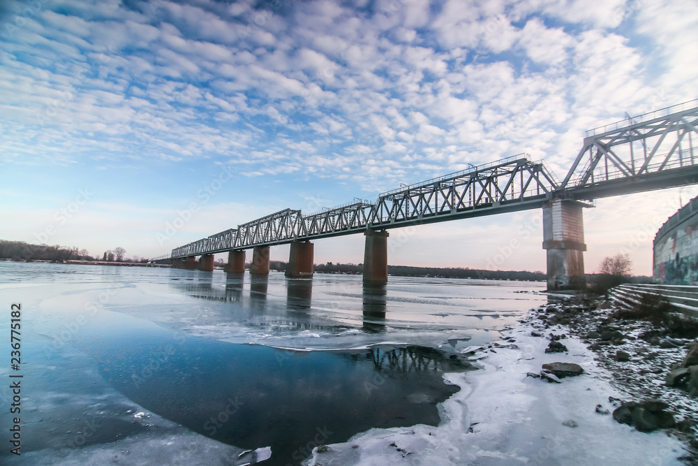 Railway bridge across Dnipro with beautiful cloudy sky in Kyiv, Ukraine