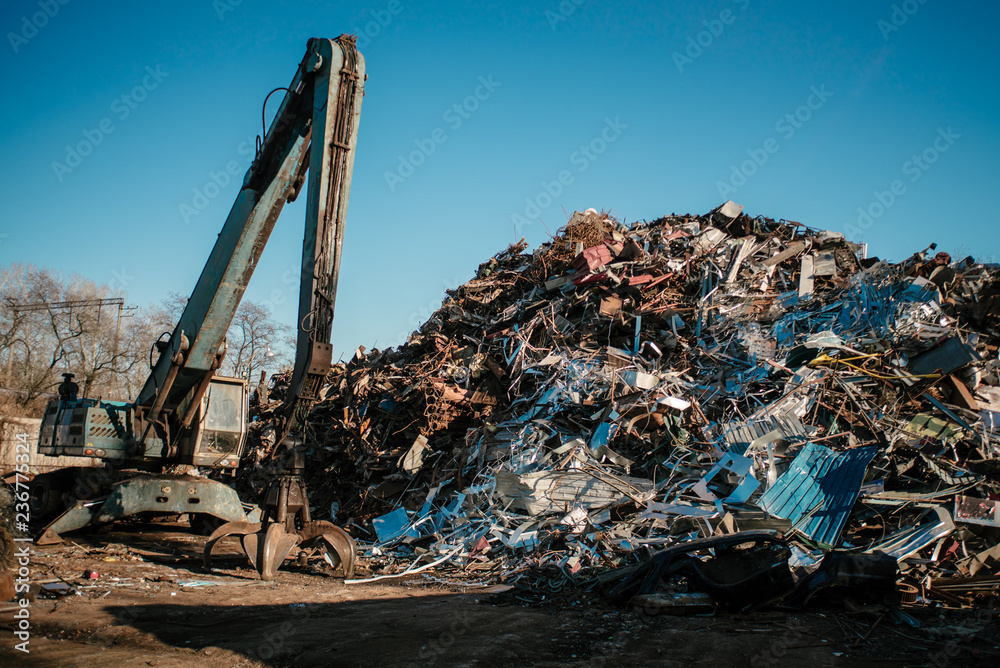 Recycling station. Metal dump with working crane and deep blue sky Recycling station. Metal dump with working crane and deep blue sky
