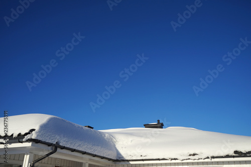A lot of snow on the roof at winter.