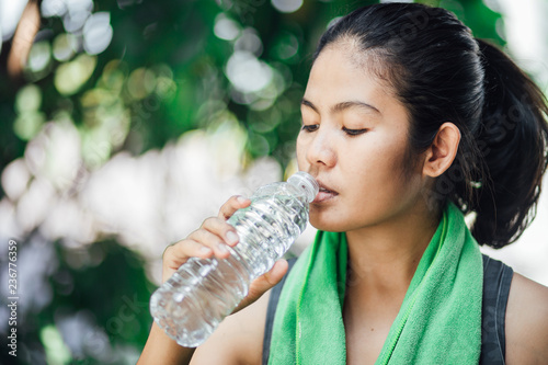 fitness athlete asian woman drinking after jogging