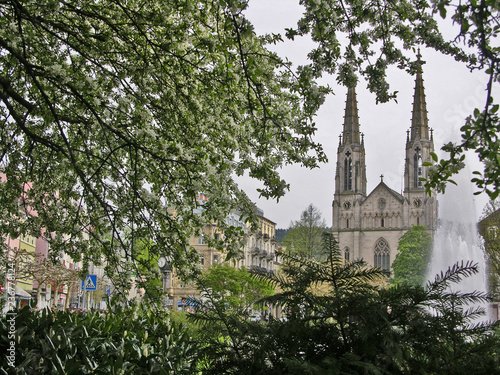 Evangelische Stadtkirche am Augustaplatz in Baden-Baden mit Zweigen und Blüten im Vordergrund
 photo