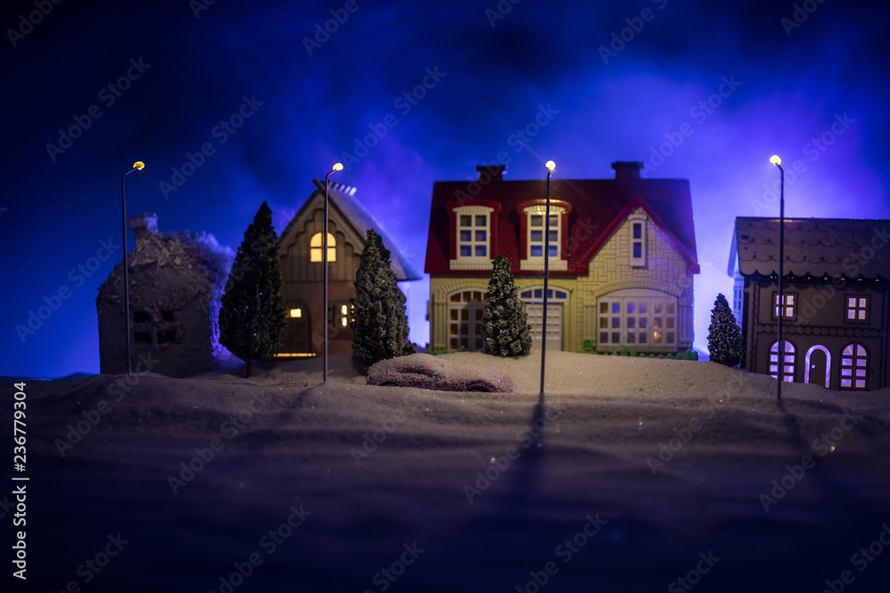 Little decorative houses, beautiful festive still life, cute small houses at night, Night city real bokeh background, happy winter holidays. Selective focus