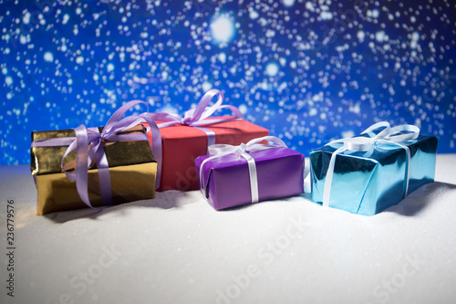 Christmas gift or New Year with blue ribbon on rustic wood table on bokeh background. Handmade gift concept.