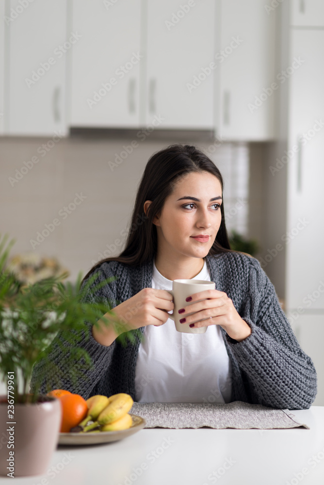 Beautiful woman with cup of coffee day dreaming at home Beautiful woman with cup of coffee day dreaming at home