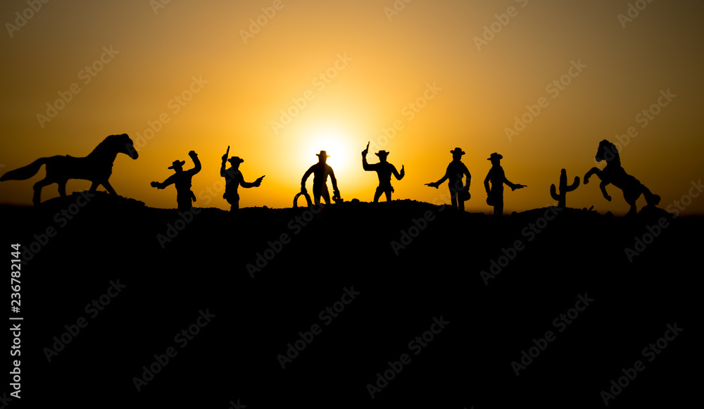 Cowboy concept. Silhouette of Cowboys at sunset time. Cowboys silhouettes on a hill with horses. Cowboy concept. Silhouette of Cowboys at sunset time. Cowboys silhouettes on a hill with horses.
