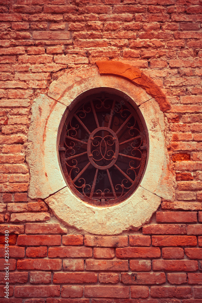 A small rusty window of circular shape.