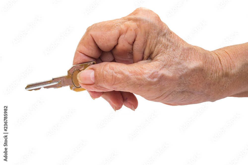 Senior woman's right hand holding key isolated on white background Senior woman's right hand holding key isolated on white background