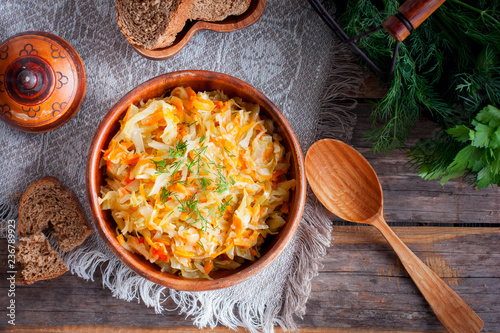 Braised cabbage in a wooden bowl, top view, selective focus