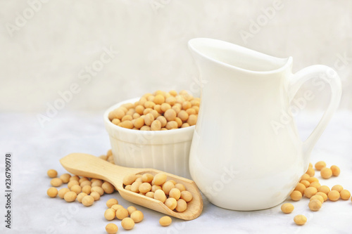 Soybean milk on dry soya beans background, vegan protein legumes for healthy vegetarian diet, selective focus