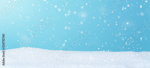 Snowfall over blue sky in a snow covered landscape