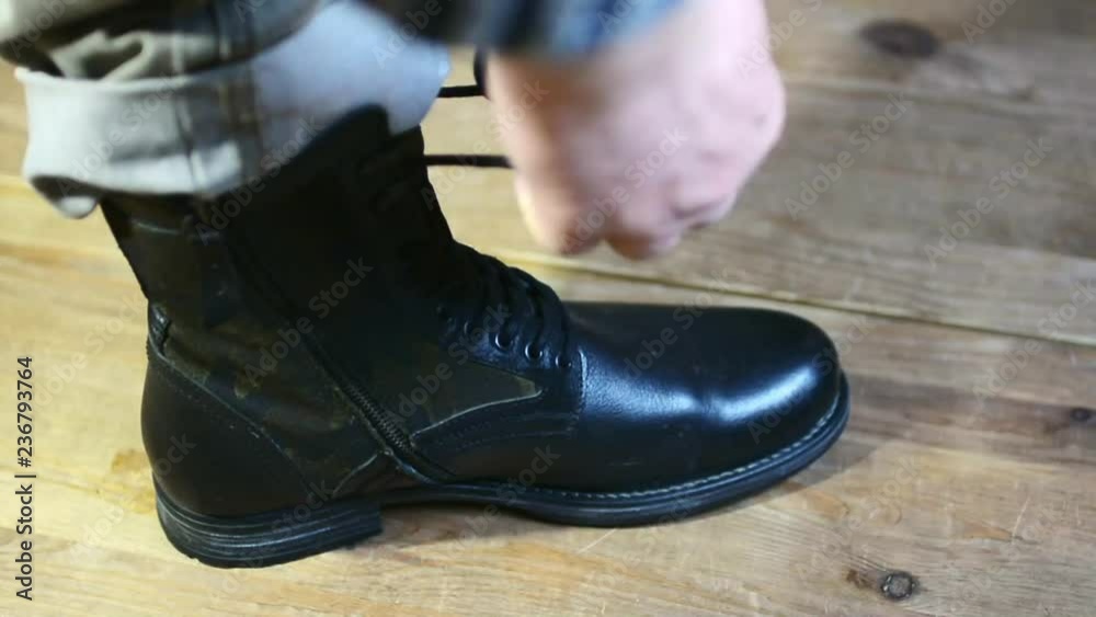 A man tying shoelaces on his shoes A man tying shoelaces on his shoes