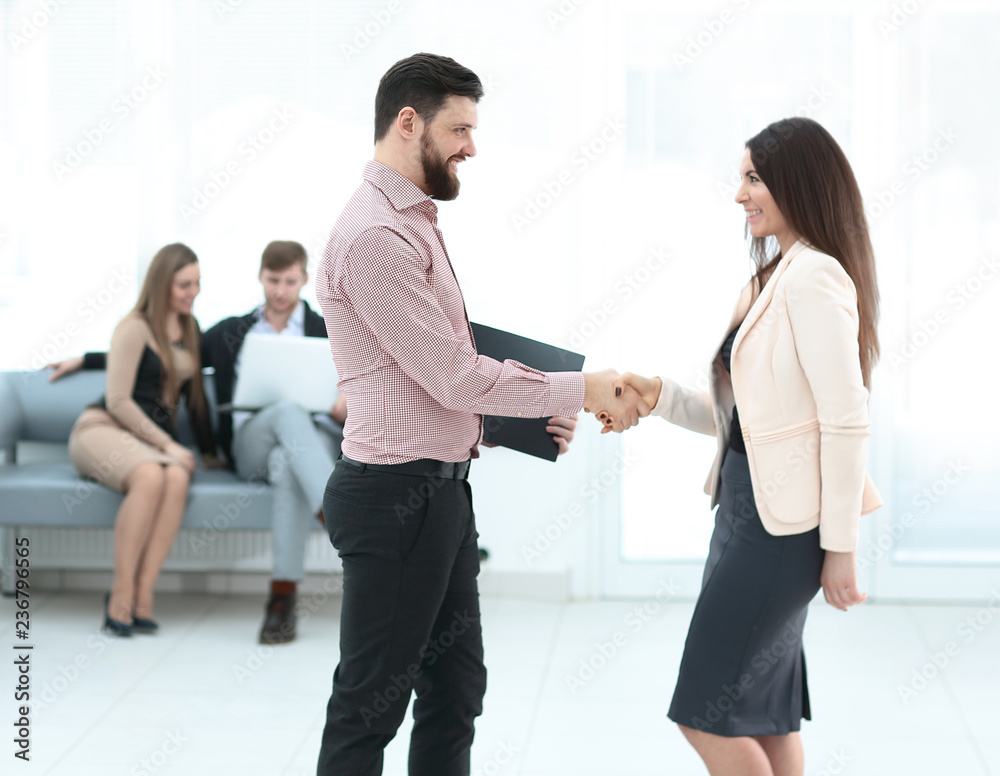 Business partners shaking hands in meeting hall Business partners shaking hands in meeting hall