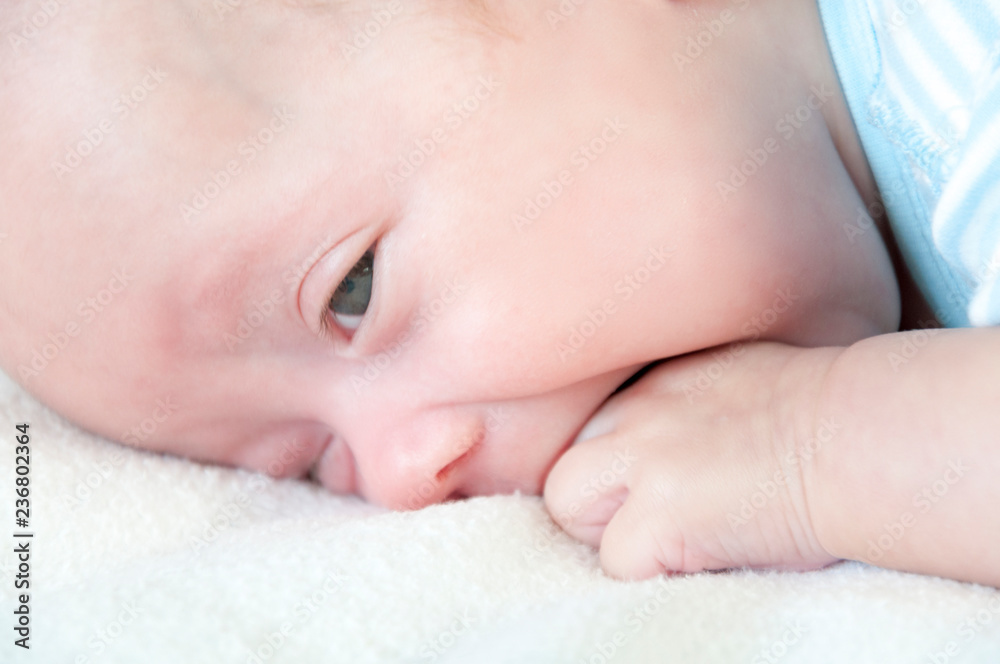 The baby cries and pulls the handle into his mouth because of the cutting teeth. Selective focus. The baby cries and pulls the handle into his mouth because of the cutting teeth. Selective focus.