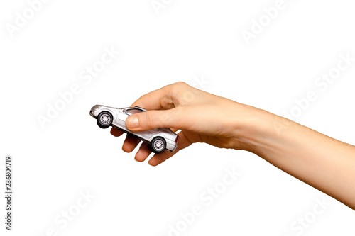 Female hand holding a grey toy car, isolated on white