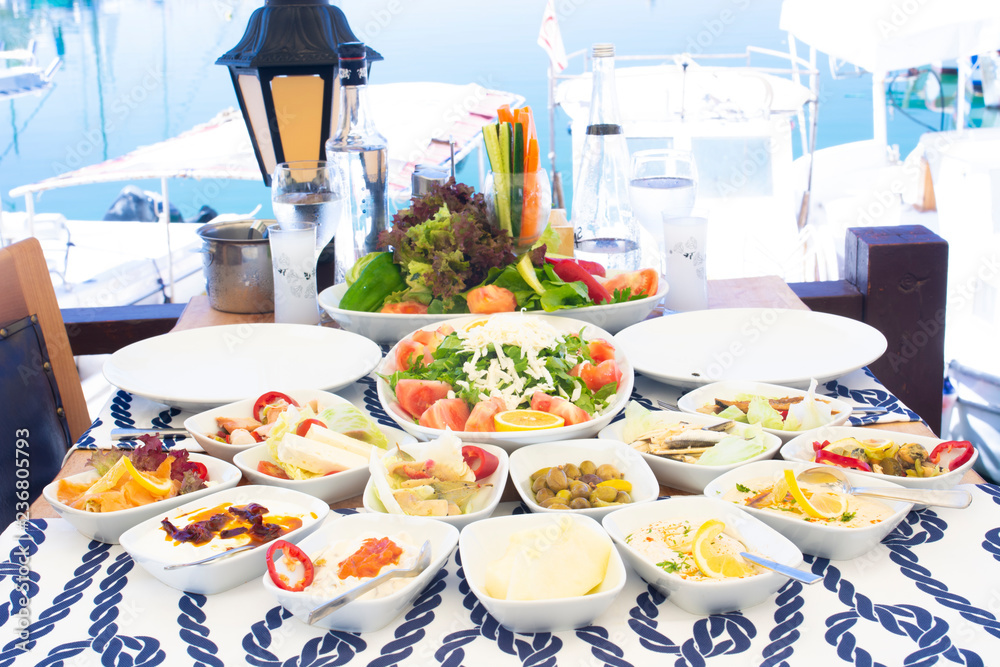 Seafoods, fish, salad and mezes on the table near the sea