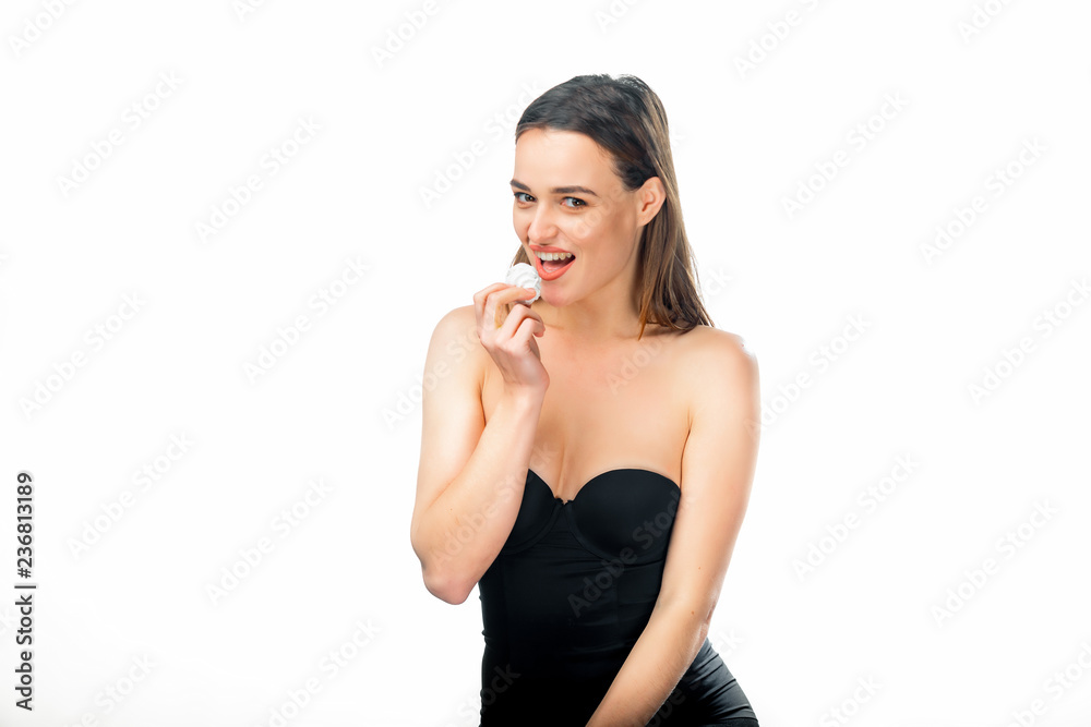 A sexy young attractive model wearing black lingerie and eating sweet marshmallow on a white background. Beautiful woman taking a tasty bite out of a white marshmallow. A sexy young attractive model wearing black lingerie and eating sweet marshmallow on a white background. Beautiful woman taking a tasty bite out of a white marshmallow.