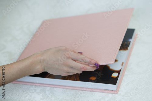 photo book with  leather cover
unfolded photobook
background for photo publishing
sample photobook
the person is looking at a photobook