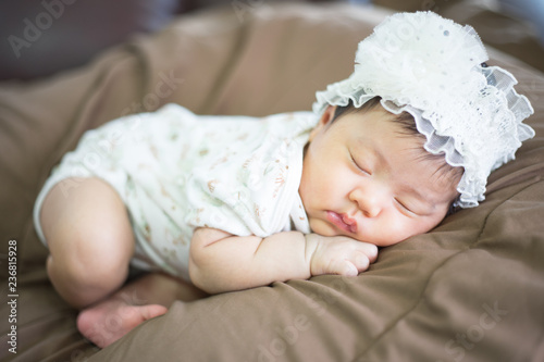 Infant sleep on gentle bed and look like she have a sweet dream