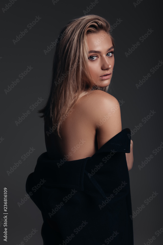 Naklejka premium Fashion model with a nude make-up, dark background, stylish girl