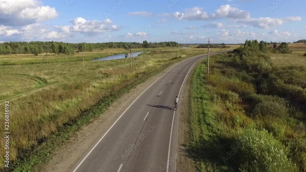 Aerial view: nature in Russia. Biker going on road Aerial view: nature in Russia. Biker going on road