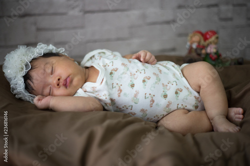 Infant sleep on gentle bed and look like she have a sweet dream