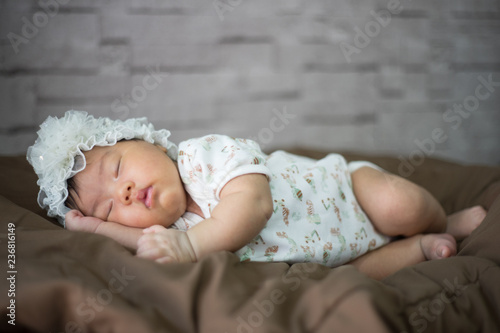 Infant sleep on gentle bed and look like she have a sweet dream
