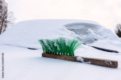 Obraz na plátně On the snowbound car hood lies a green brush