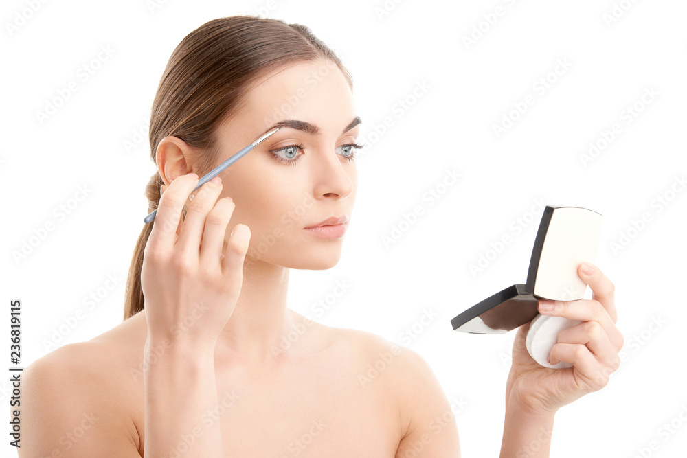 Young naked woman applying makeup. Studio shot. Young naked woman applying makeup. Studio shot.