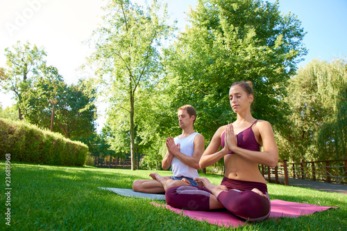 Young couple doing yoga outdoors