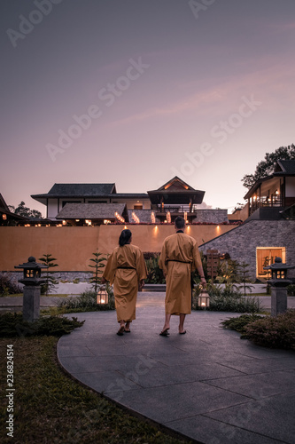Canvas Print happy young couple walking with oil lamp over a bridge wearing kimono, man and w