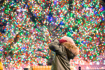 Happy girl on the background of the Rockefeller Christmas tree in New York