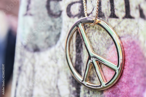 Close up of golden peace symbol necklace
