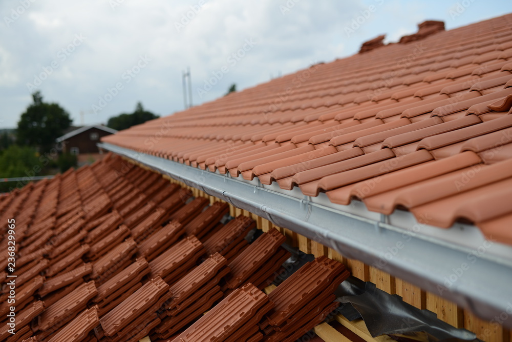 Ziegeldach Bauarbeiten beim Hausbau: Dachdecker Dach mit Dachziegel Ziegelstein Tradition