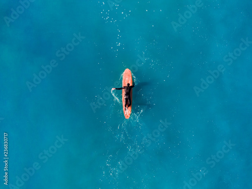 Surfer top of wave in ocean, top view aeria