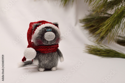 Knitted toy grey cat in Santa's cap