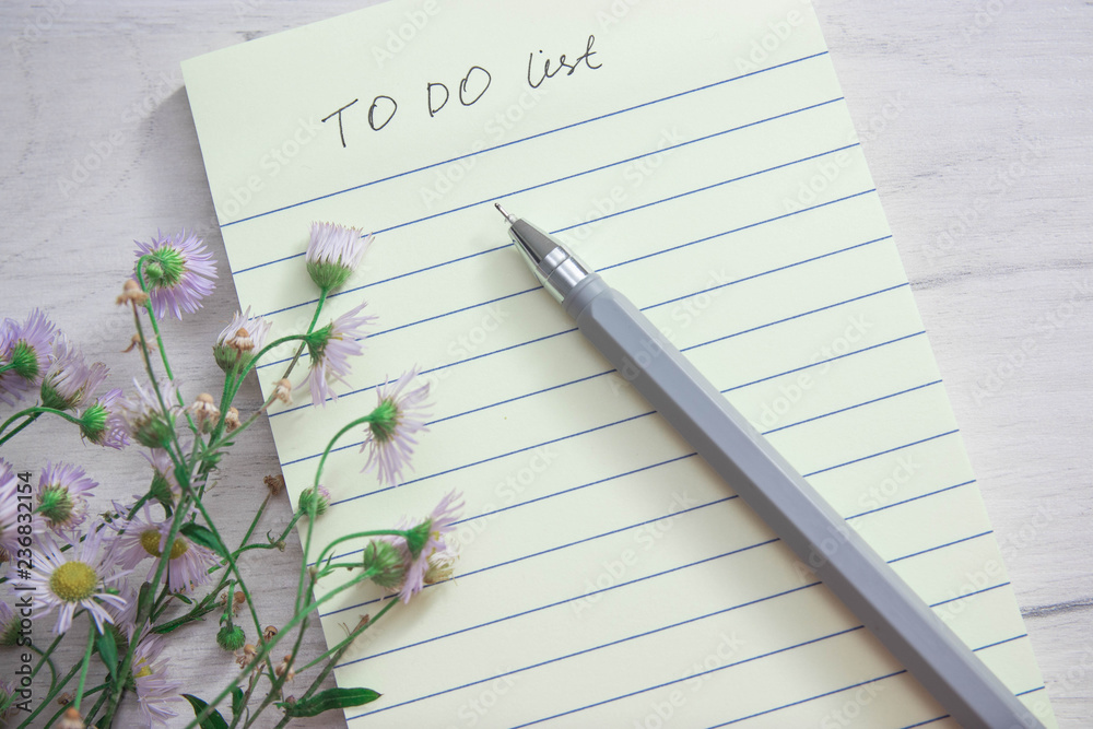 Naklejka premium day planning notebook, notepad, daisy flowers, top view, copy space.