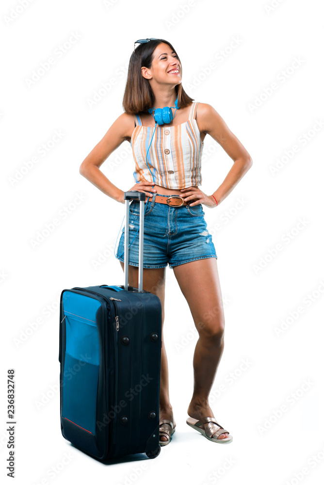 Full body of Girl traveling with her suitcase posing with arms at hip on isolated white background Full body of Girl traveling with her suitcase posing with arms at hip on isolated white background