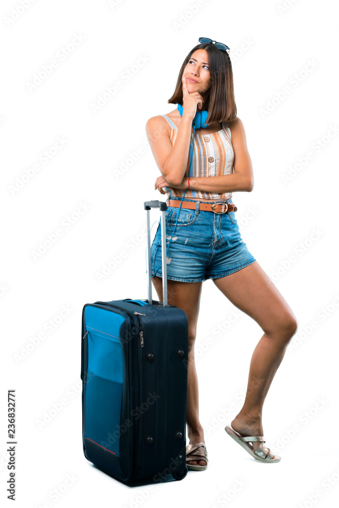 Full body of Girl traveling with her suitcase standing and thinking an idea while looking up on isolated white background Full body of Girl traveling with her suitcase standing and thinking an idea while looking up on isolated white background